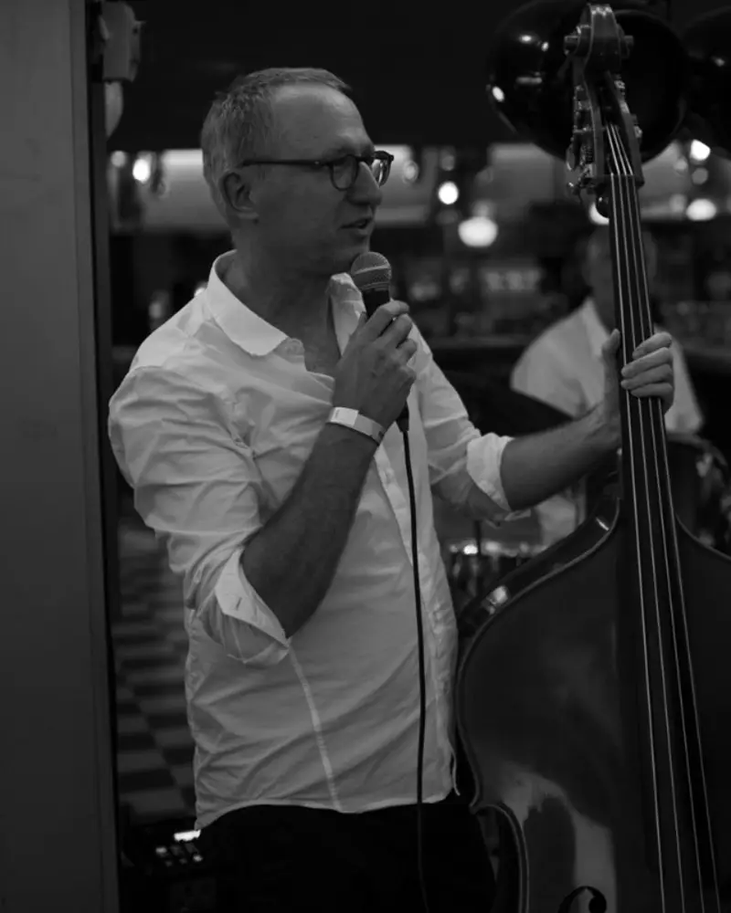 Simon Hefti am Kontrabass, mit Mikrofon in der Hand